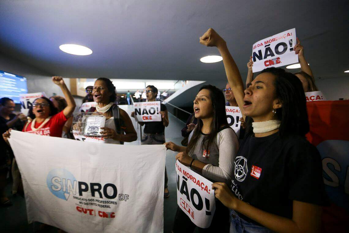 Manifestantes contra o projeto de lei sobre a Escola sem Partido protestam durante reunião da Comissão Especial da Câmara que discute a matéria (Foto: Marcelo Camargo | Agência Brasil).