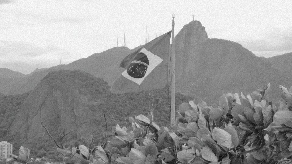 Imagem da bandeira do Brasil e ao fundo o corcovado representando a garantia dos direitos humanos no Brasil