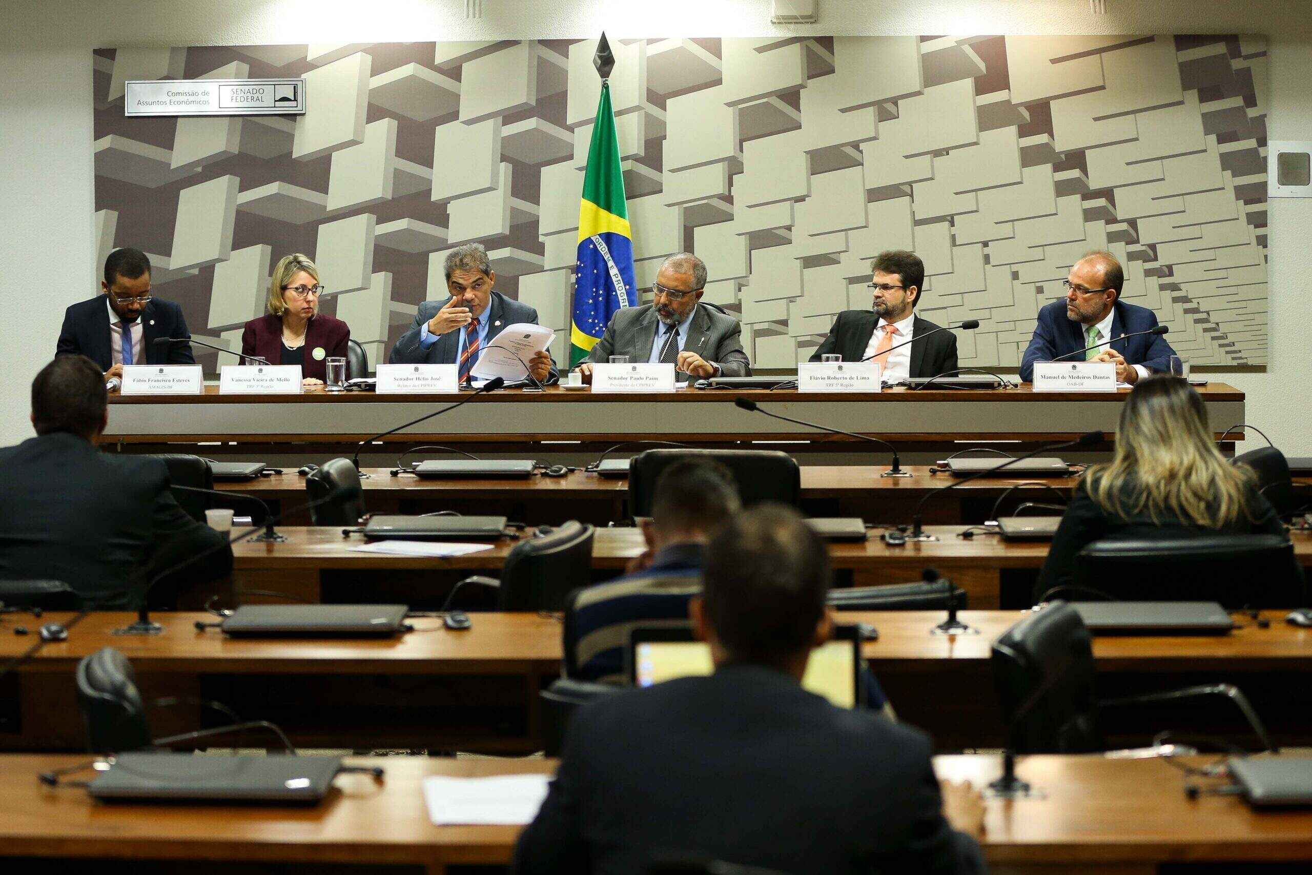 Na imagem, ministros conversando durante reunião da comissão parlamentar. Conteúdo sobre comissões parlamentares