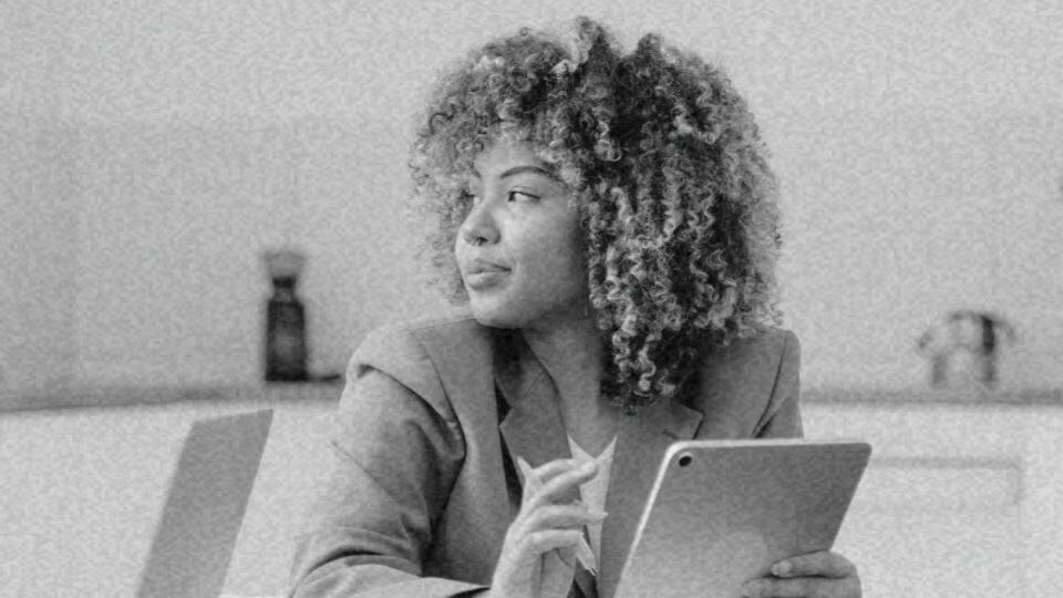 Imagem de uma mulher negra trabalhando representando a discriminação racial no mercado de trabalho