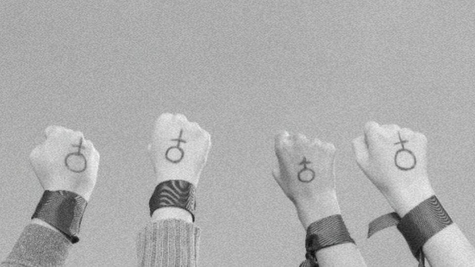 Mulheres com suas mãos levantadas reivindicando a equidade de gênero