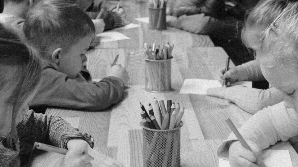 Imagem de diversas crianças desenhando e pintando em uma mesa representando o direito à educação infantil e a construção da cidadania