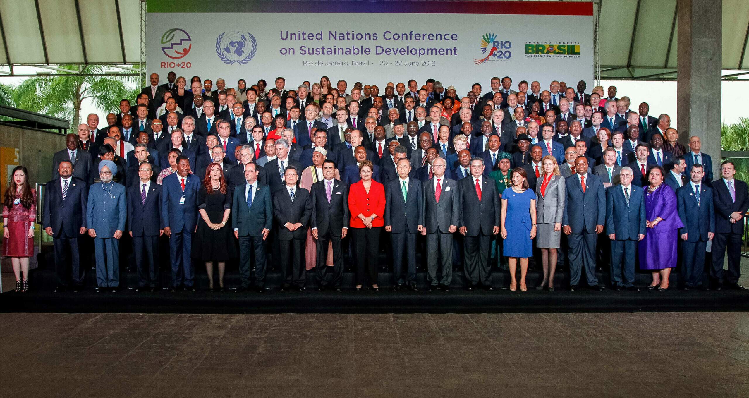 Na imagem, líderes mundiais posando em frente ao painel da Rio+20. Conteúdo sobre os Objetivos de Desenvolvimento Sustentável.
