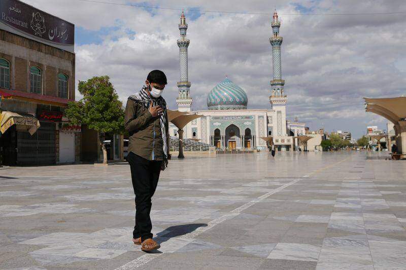 Homem com máscara de proteção caminha pelas ruas do Irã. Conteúdo sobre coronavírus e o Oriente Médio.