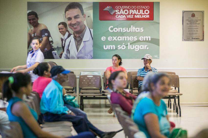 Na imagem, pessoas sentadas esperando em uma sala de espera de hospital. Conteúdo sobre Judicialização da saúde no Brasil.