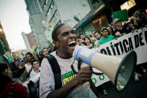 Homem negro com megafone liderando uma marcha da maconha | Liberdade de locomoção – Artigo Quinto