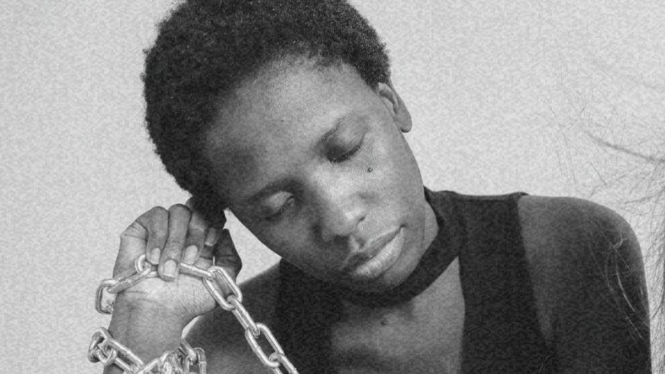 Imagem de uma mulher negra com correntes representando o racismo estrutural