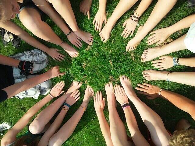 Imagem ilustrativa. (Foto: Pixabay). Pessoas reunidas em círculo, com as mãos tocando o chão.
