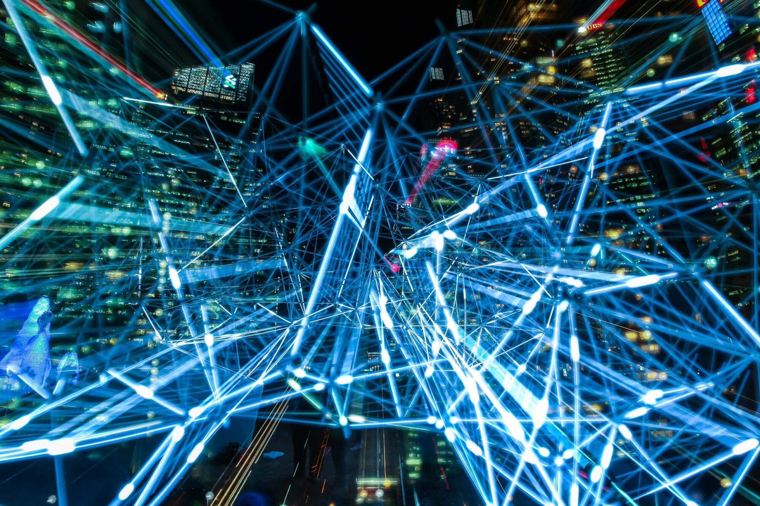 Imagem ilustrativa representado uma rede de 5g, com várias luzes azuis passando por uma cidade (Via: Pixabay)