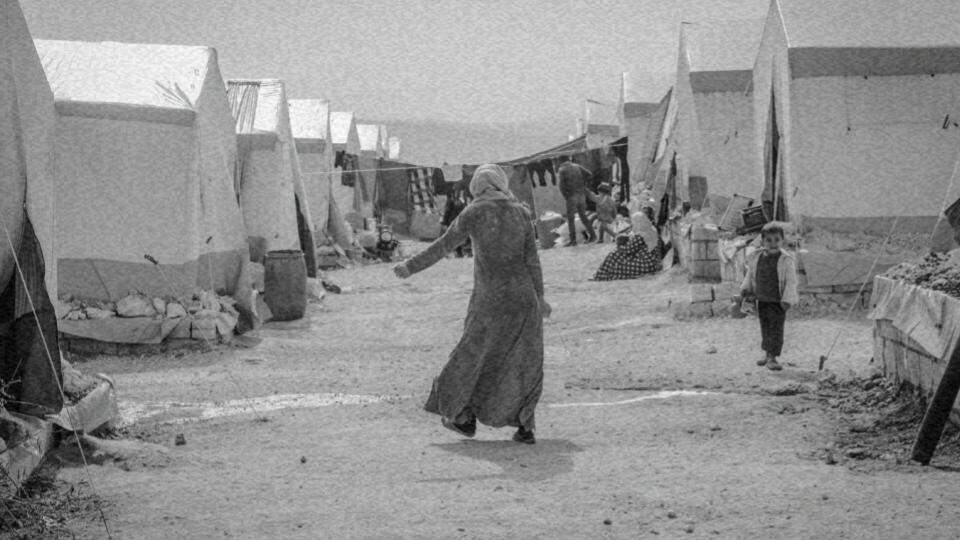 Imagem de uma mulher de costas caminhando em um campo de refugiados, representando os direitos dos refugiados e migrantes