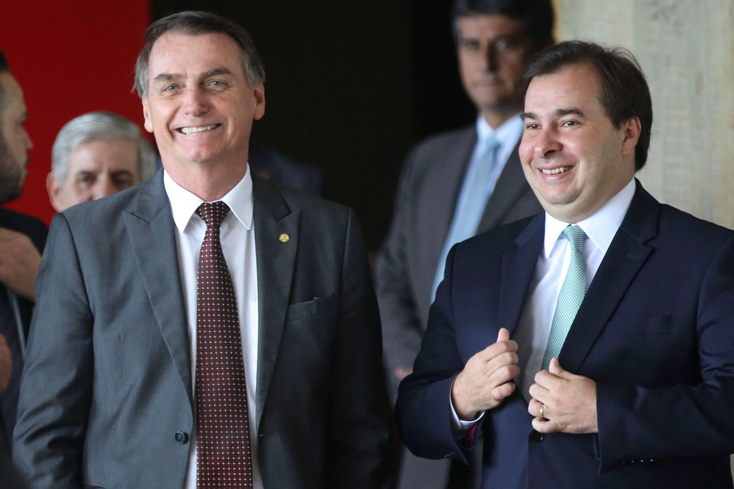 O presidente, Jair Bolsonaro, e o presidente da Câmara dos Deputados, Rodrigo Maia, em pé sorrindo. Conteúdo sobre bolsonaro e congresso em 2019