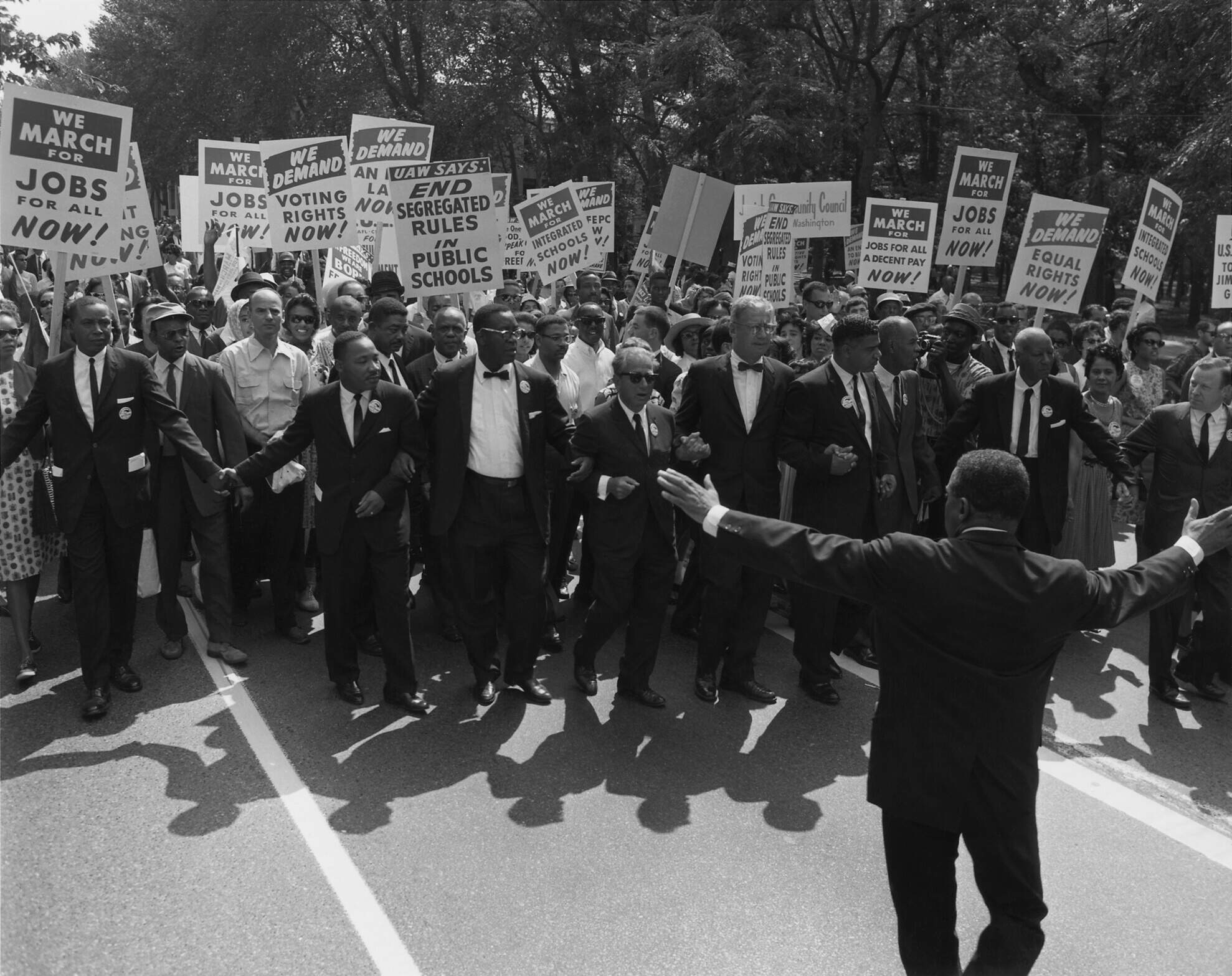 Manifestação durante o Movimento por direitos civis nos Estados Unidos com diversos cartazes pedindo maior inclusão de negroa nas diversas esferas da vida em sociedade. Foi neste período que o termo token começou a ser utilizado.