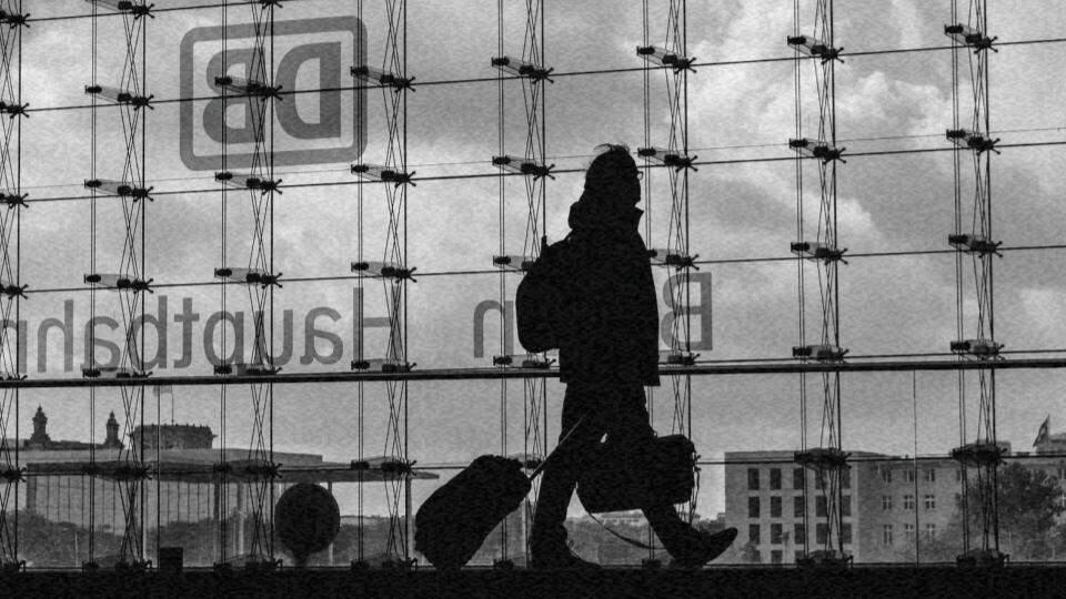 Imagem de uma mulher andando em um aeroporto, carregando as suas malas, representando o tráfico humano, como funciona e como combatê-lo