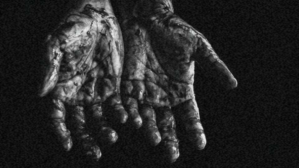 Imagem das mãos de uma pessoa negra com sangue representando a violência racial no Brasil e no mundo 