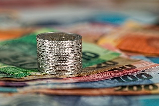 Moedas empilhadas sobre notas de dinheiro. Conteúdo sobre tesouro nacional.