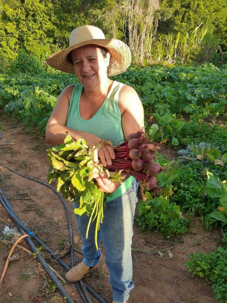 Mulher em plantação segurando rabanetes