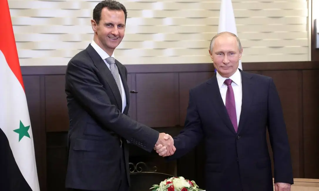 Bashar Al-Assad e Putin apertando as mãos.