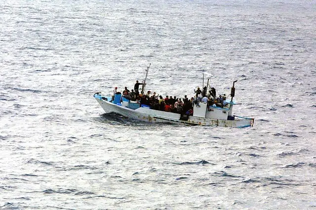 Pessoas refugiadas atravessando fronteira internacional em barco. Texto: Você sabe o que é asilo político?