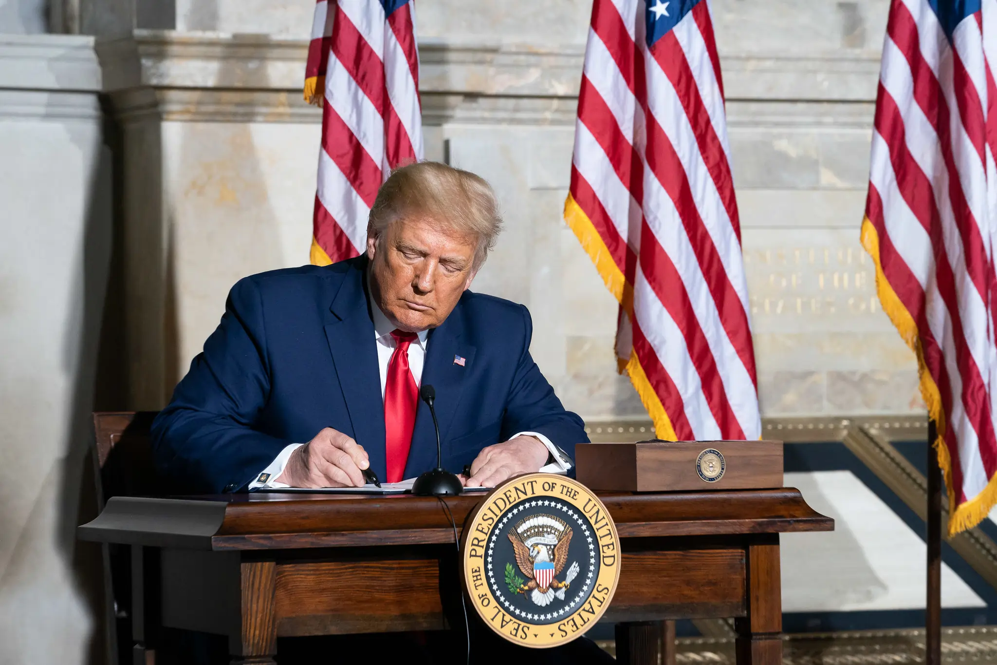 Imagem de Donald Trump assinando um documento