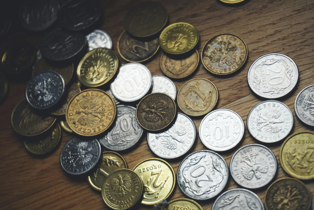 Moedas de metal simbolizando o metalismo no mercantilismo. Texto: O absolutismo e a organização de poder na Era Moderna