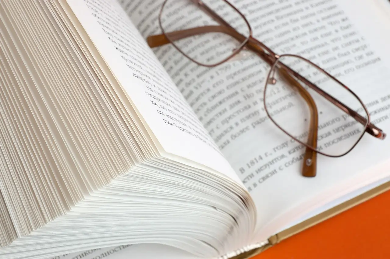 Imagem de um dicionário e um óculos de grau. Texto: Como novas palavras surgem e são oficializadas na Língua Portuguesa?