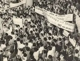 Manifestantes, durante a ditadura militar, protestando contra o regime. na foto há diversas pessoas com cartazes de protesto.
