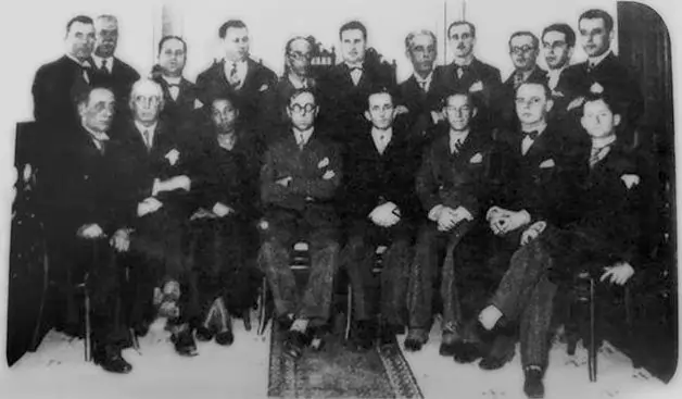 Antonieta de Barros sentada ao lado de 18 homens brancos.